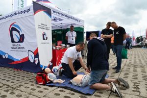 pracownik fundacji uczy pierwszej pomocy trzech mężczyzn