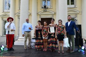 cztery kobiety i trzej mężczyźni stoją na scenie